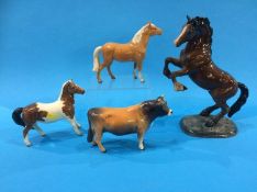 A small Beswick bull and three Beswick horses