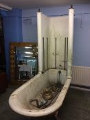 An Edwardian cast iron bath and shower, with rolled top on lion paw feet