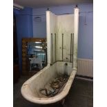 An Edwardian cast iron bath and shower, with rolled top on lion paw feet