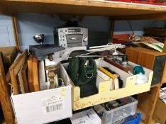 A shelf containing a karaoke machine, pictures, DVDs etc.