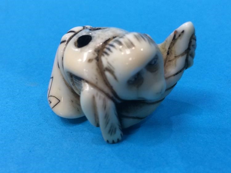 Netsuke; of a monkey kneading bread