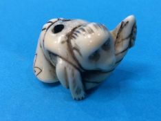 Netsuke; of a monkey kneading bread