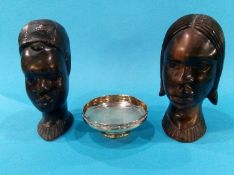 A small silver bowl and two carved heads