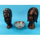 A small silver bowl and two carved heads