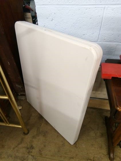 A folding white plastic table