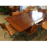 A modern refectory table with six wrought iron and leather chairs