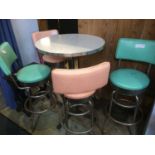 A 1950s style circular top table, with two lime green and two pink high stools