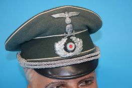 A German Infantry Officer's visor cap, with metal eagle, swastika badge, oak leaves and red felt