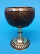 A silver metal mounted coconut cup, carved in relief with various coins, dated 1768 and palm