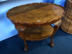 A walnut two tier oval occasional table with claw and ball feet