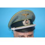 A German Signals Officer's visor cap, with bronze eagle, stamped Fahnen-Reuter, Munster, I.M.