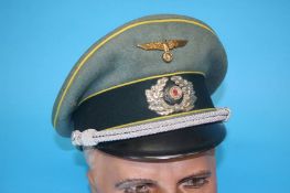 A German Signals Officer's visor cap, with bronze eagle, stamped Fahnen-Reuter, Munster, I.M.