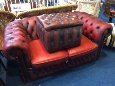 An oxblood Chesterfield two seater settee and footstool