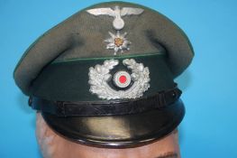 A German Gebirgstruppe (Mountain Troop) Non-Commissioned Officer's (NCO) visor cap, with metal