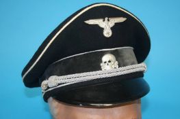 A German Third Reich Allgemeine SS Officer's visor cap, with metal eagle and swastika badge and
