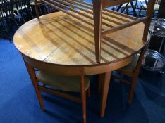 A teak extending circular table with four chairs