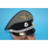 A German Medical Officer's visor cap, with dark blue piping, brass eagle and swastika badge and
