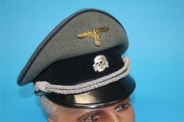 A German Medical Officer's visor cap, with dark blue piping, brass eagle and swastika badge and