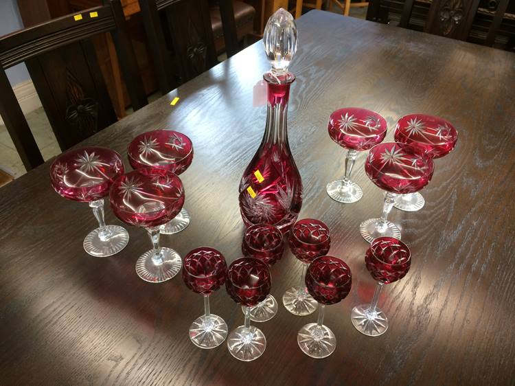 A Cranberry coloured cut glass decanter, six champ