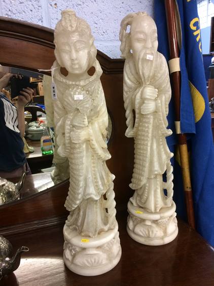 A pair of carved Oriental figures, 61cm high