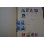 Red tatty stamp album containing a mixture of worl