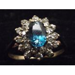 9ct Gold ring with central blue stone surrounded b