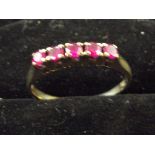 Yellow metal ring set with rubies