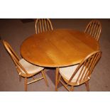 Ercol elm dining table, oval dropleaf top over spl