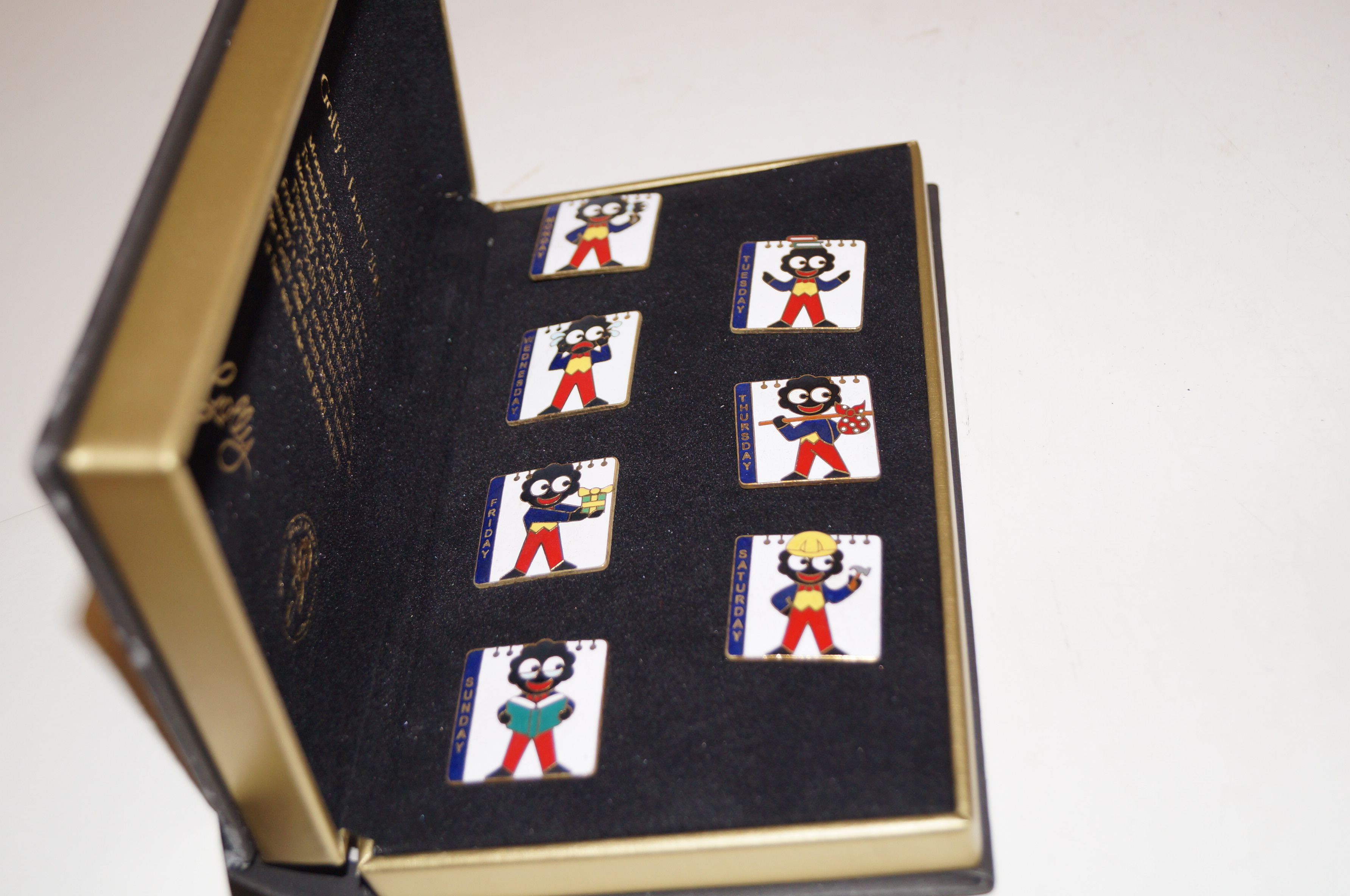 Cased Golly's diary (2001) with seven pin badges