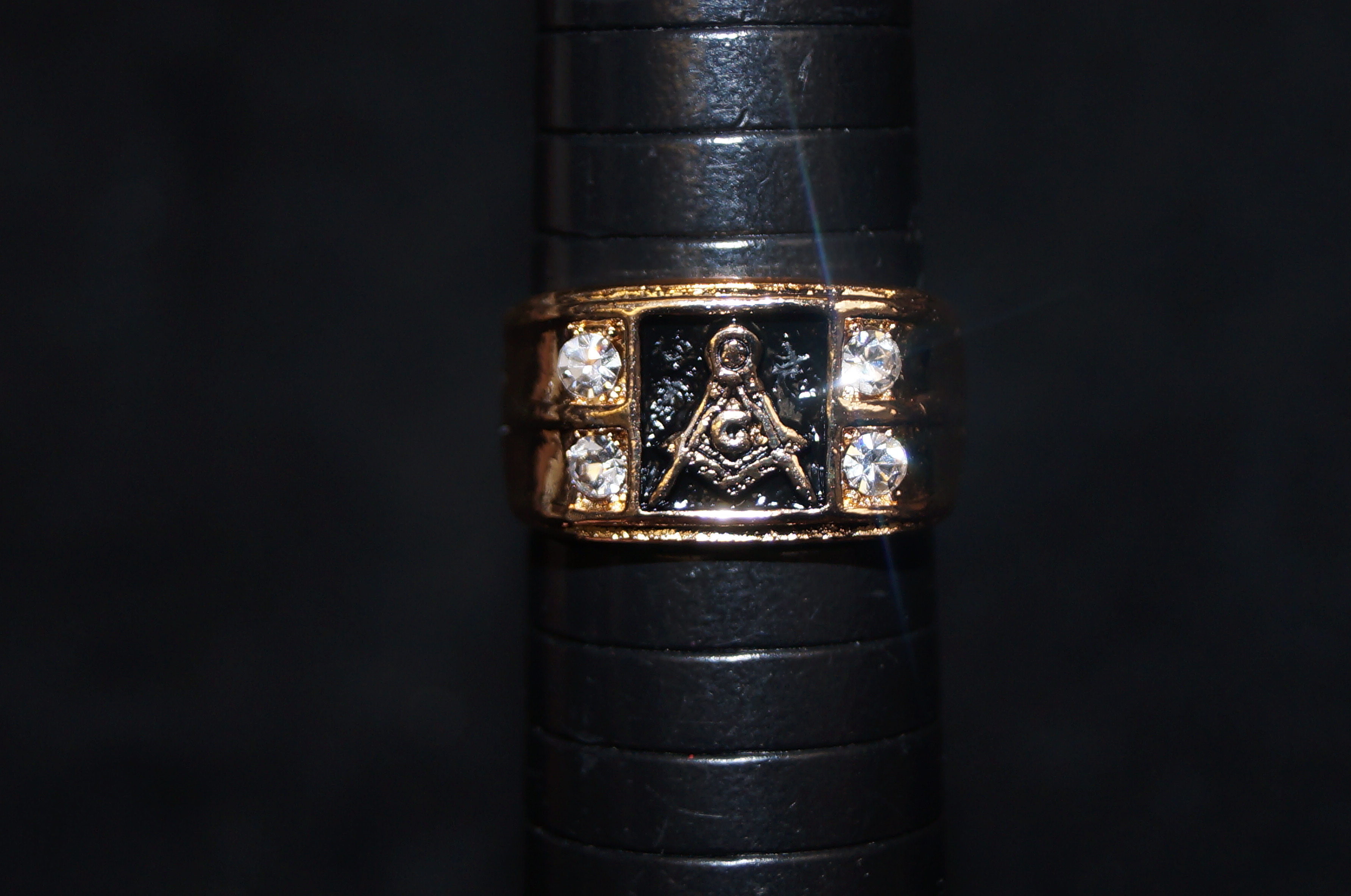 Yellow metal Masonic ring set with 4 white stones.