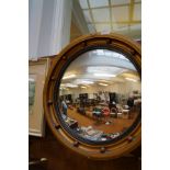 Circular convex porhole mirror set in a gilt frame