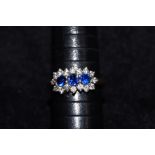 9ct gold ring set with 3 blue stones and a cluster