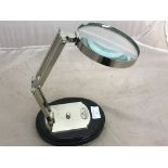 A chrome magnifying glass on a black base