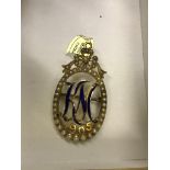 An Edwardian gold pearl and enamelled cypher brooch/pendant" KM 1905" no hallmarks: tests as 9ct