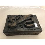 An Oriental wooden box with carved dragon decoration