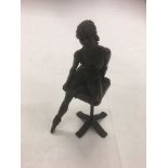 A bronzed figure of a seated ballerina