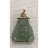 A 14k gold pendant of a seated Buddha in hat with filigree Chinese character to the back