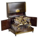A Tantalus: 19th century, in a mahogany fold out box with brass floral and line inlay,
