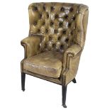 A Leather Armchair: With arched button back design, on four tapered legs and castors,