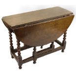 A 17th Century Oak Gate Leg Table: On six pullout type turned legs,