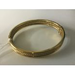 A 9ct torsion lock bangle