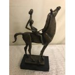 A stylised bronze of a nude lady on horseback