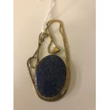 A lapis lazuli oval gold-mounted pendant on a gold chain