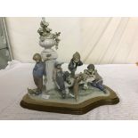 A large Lladro figure group of children and dogs by a column;