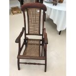 A late 19th early 20th century folding steam chair with rattan panel