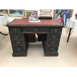 An oak carved leather-topped desk