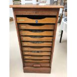 A 1940s oak roll shutter filing cabinet