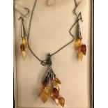 A silver and amber set: earrings and necklace