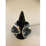 A silver abstract dress ring with blue topaz