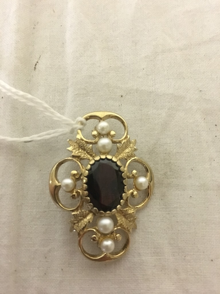A gold pearl and garnet brooch